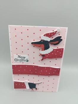 Fröhliche Weihnachtskarte mit Dackel im Weihnachtsoutfit Kurzbeschreibung: Stilvolle Weihnachtskarte mit verspieltem Dackelmotiv in festlichem Outfit; ideal als persönlicher Gruß oder Beilage zu Geschenken. Lange Produktbeschreibung: Diese hochwertige Wei